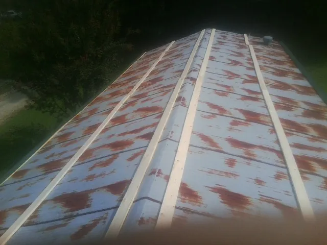 Rusted metal roof panels with new wood purlins before replacement — Storm Damage Roof Repair in Kamrar by Roofing Brothers