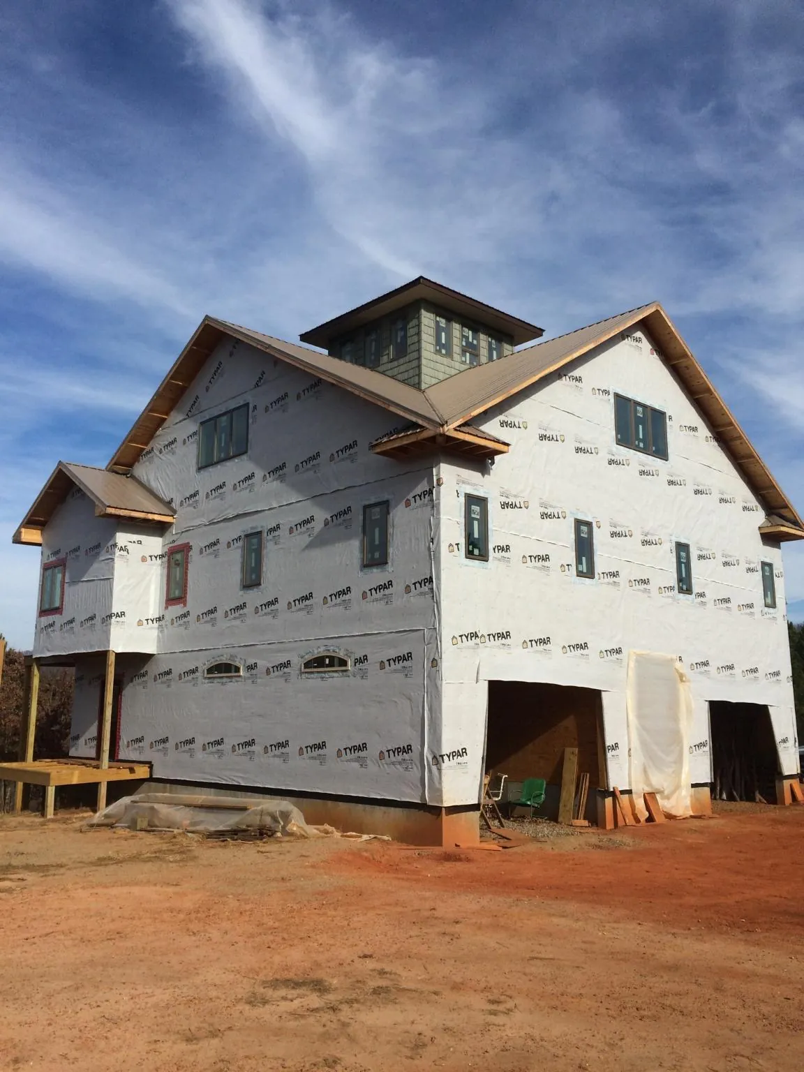 New two story house under construction with a cupola and gabled roofs in Kamrar